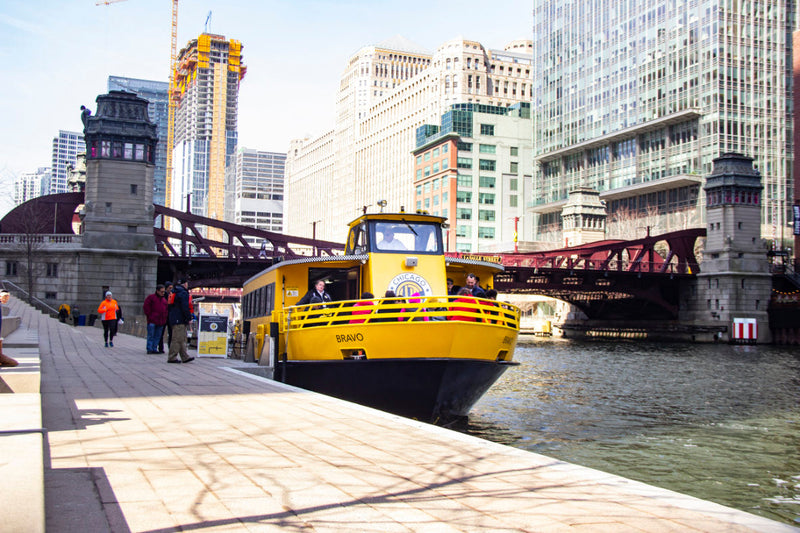 A covered Chicago Water Taxi boat arriving at the dock, ready for passengers on a rainy day