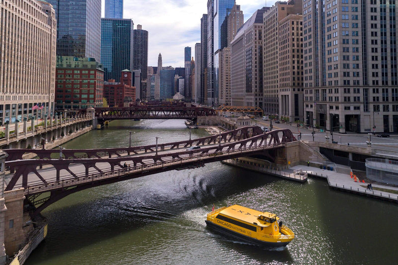 Chicago Water Taxi boat on the Chicago River with downtown traffic and skyline behind it